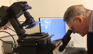 Jean-Paul Baudecroux regarde dans un microscope