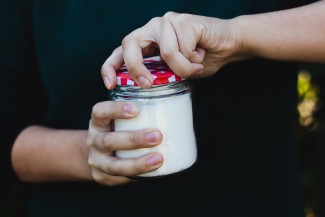 Une personne ouvre un pot de confiture