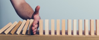 Main qui arrête la bascule de dominos